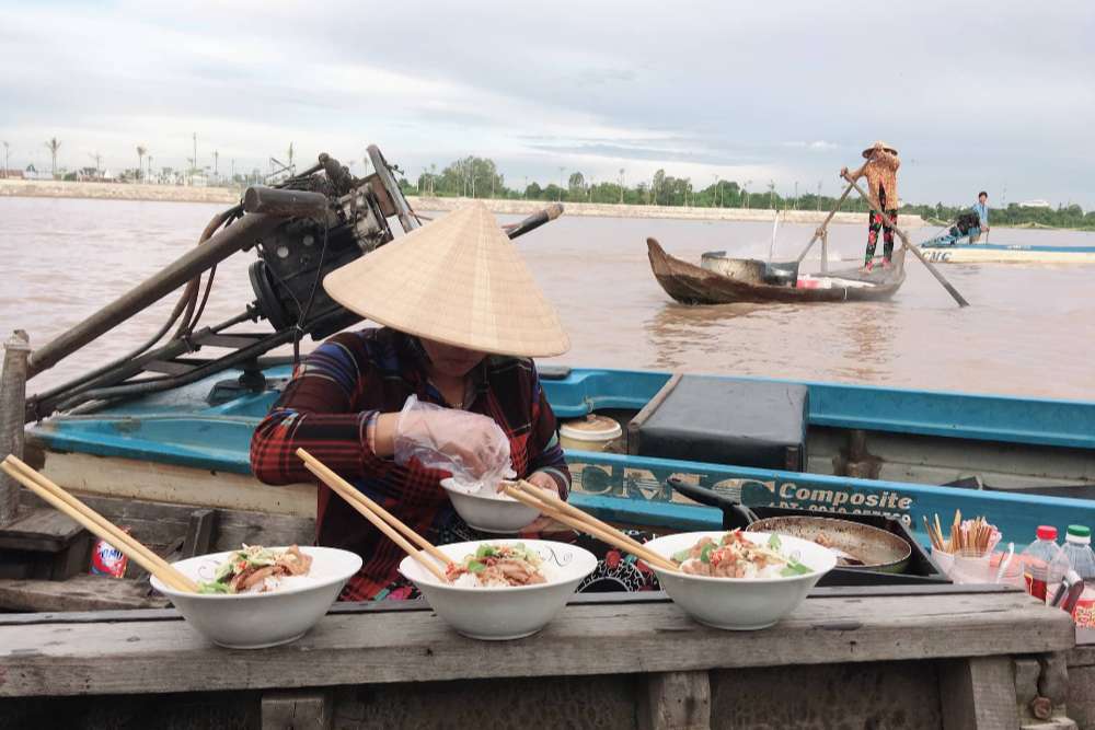 Mujer vendiendo fideos en el mercado flotante de Long Xuyen, en el delta del Mekong, Vietnam.